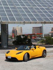 The Amonix 7700 Solar Power Generator (53 kW AC, PVUSA conditions) with a Roadster plugged into the pedestal (for scale)
